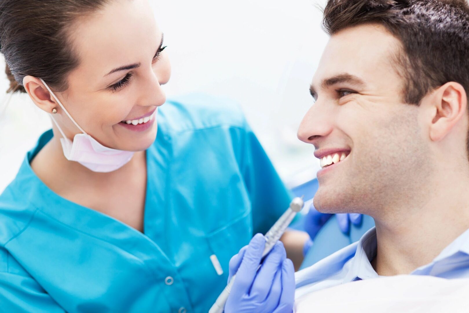 A dentist and a patient smiling at each other